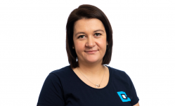 Dark-haired woman wearing a dark blue top with logo on it