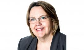 smiling woman with glasses wearing dark blue jacket